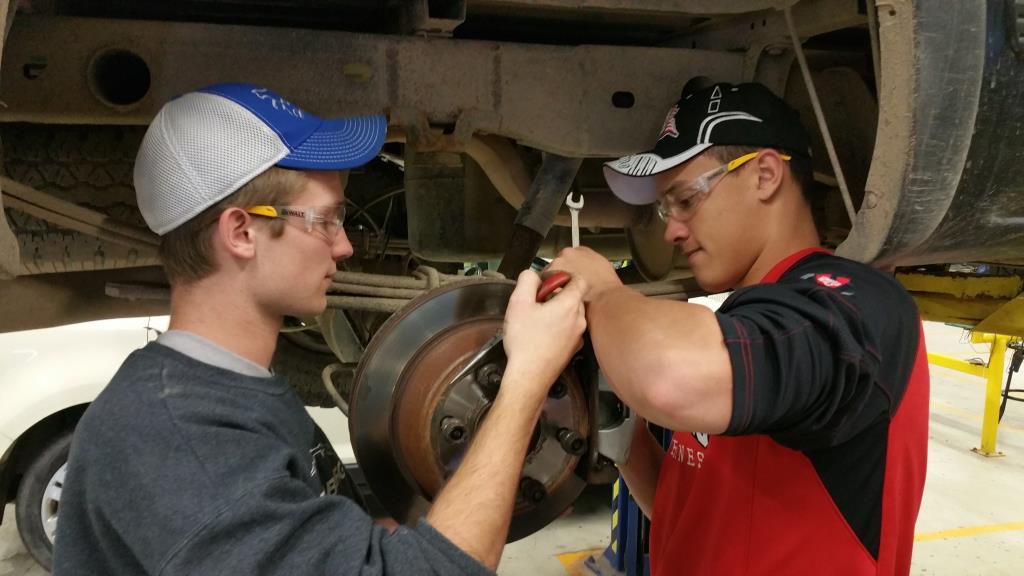 Students working on a wheel in auto class.