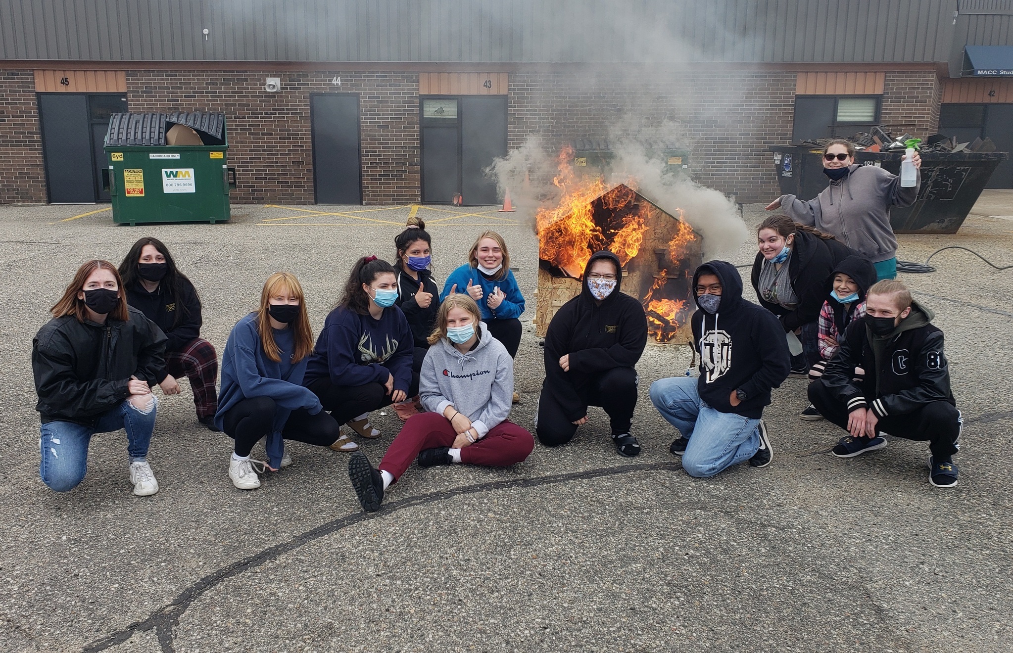 Public safety students burning a model to investigate fire science.