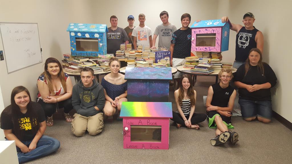 English students with the Little Free Libraries they painted, as well as the books from their book drive to fill them.