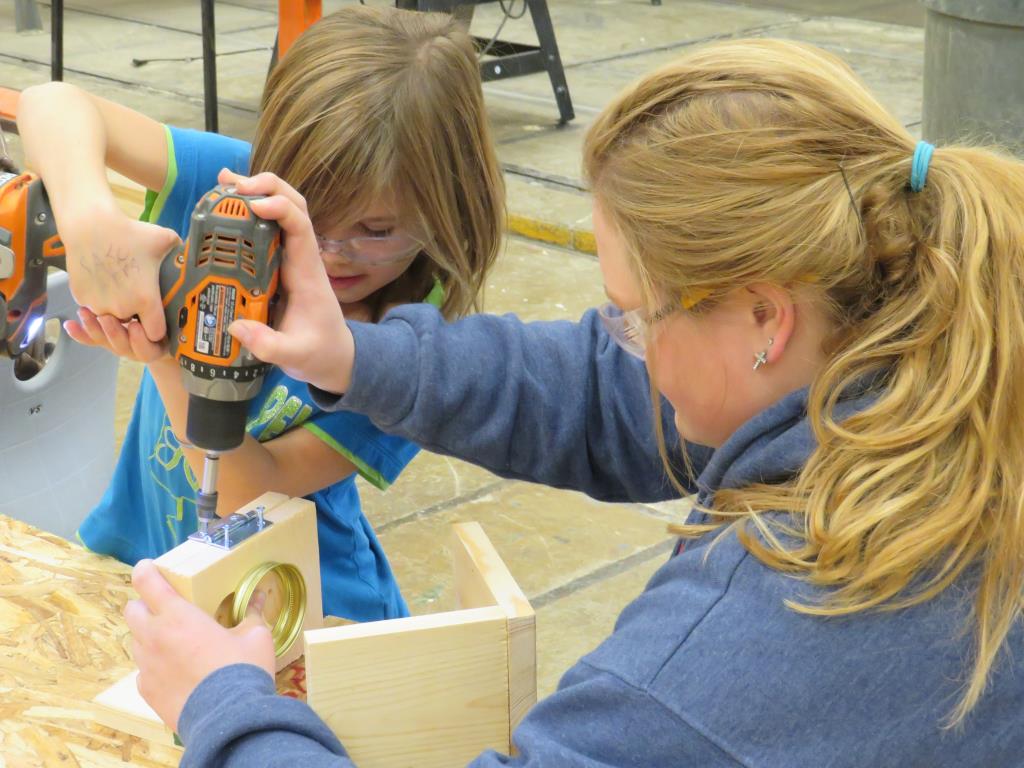 Constructions students help second graders build a bird feeder.