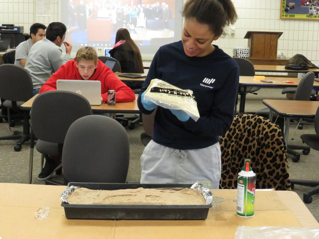 Criminal justice students work on taking molds of footprints.