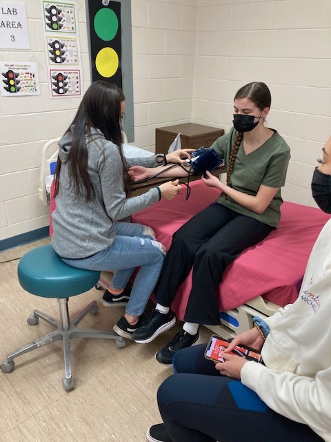 Health students practicing taking vital signs.