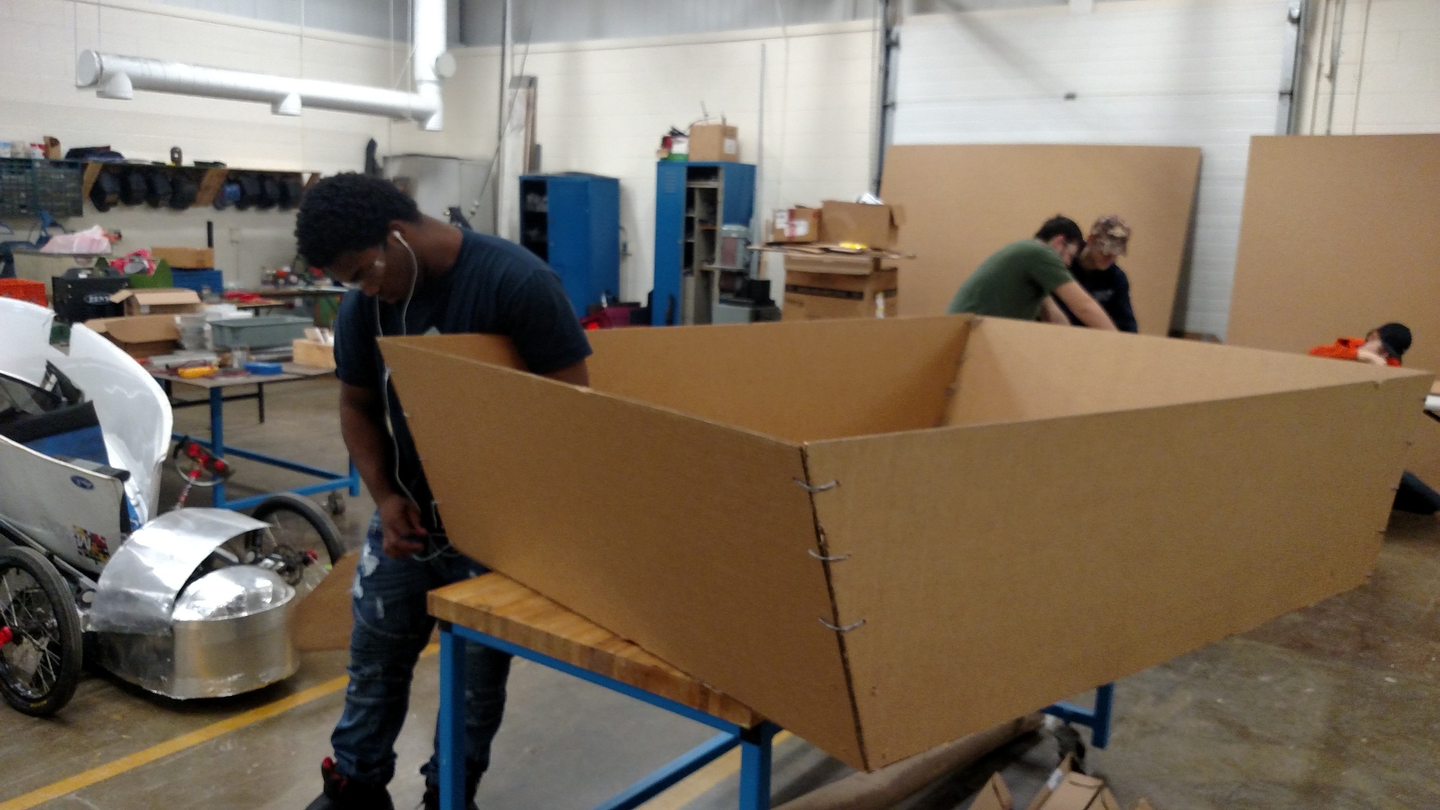 Students working on building cardboard boats for a race.