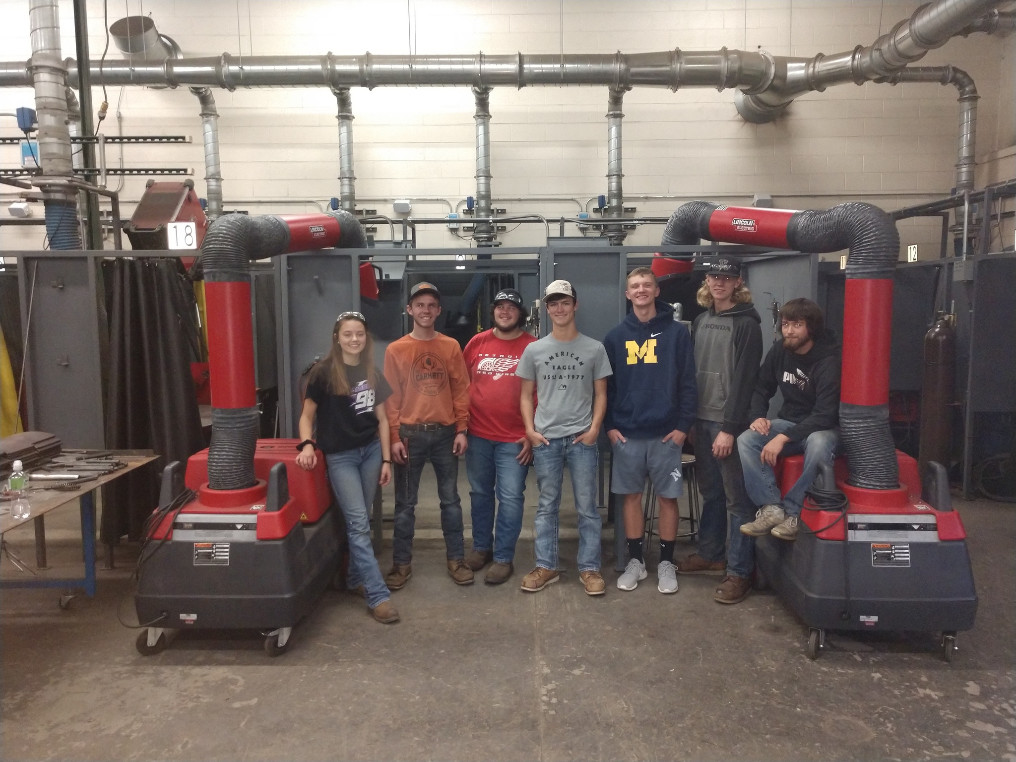 Students standing next to the two new welding booths that they fabricated.
