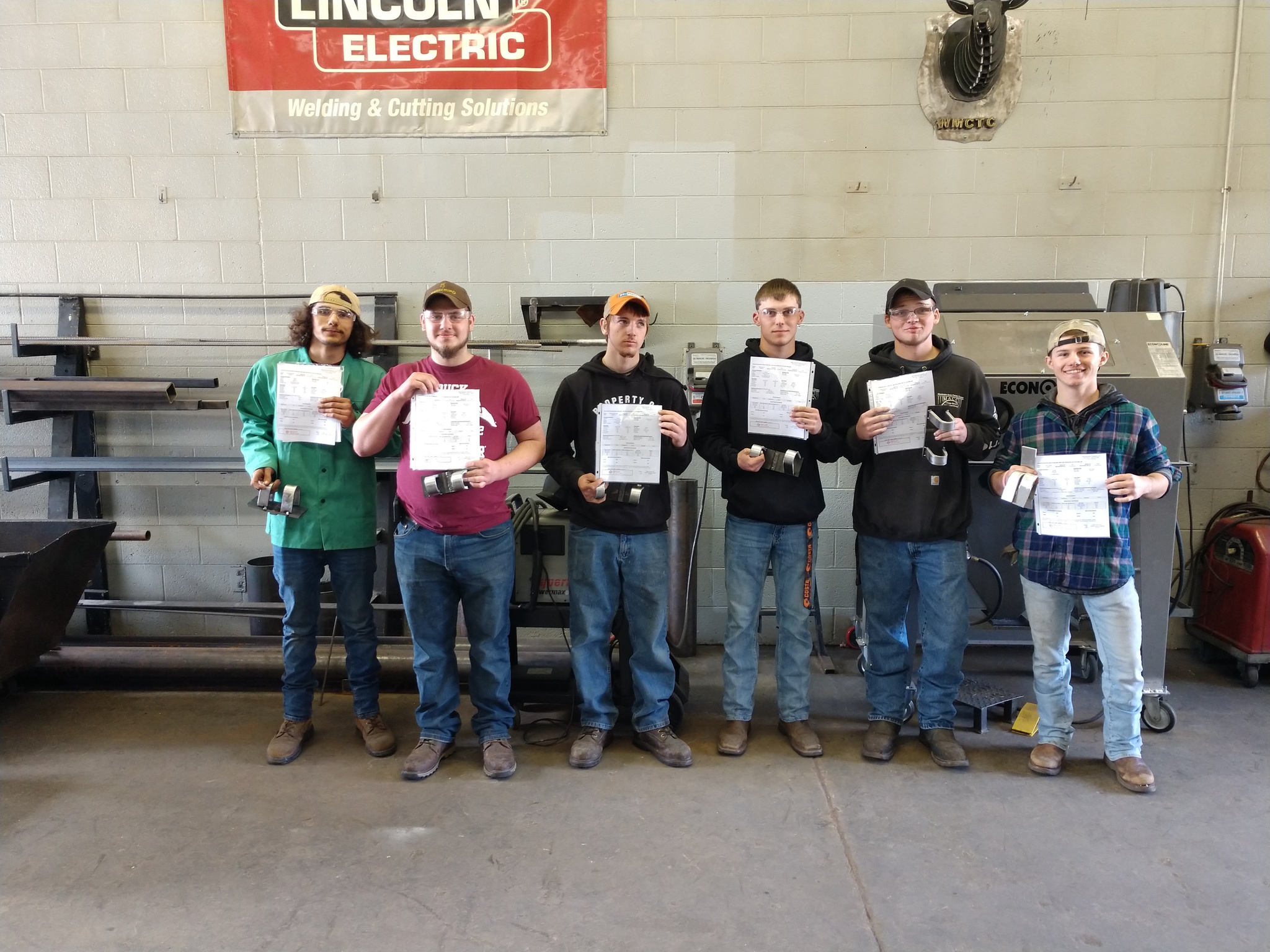 Welding students holding their new welding certifications.