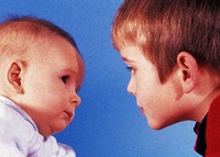 Baby and toddler boy looking at each other.