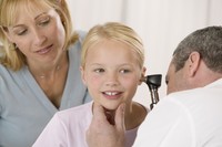 Doctor checking child's ear