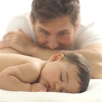 A father observing baby sleeping